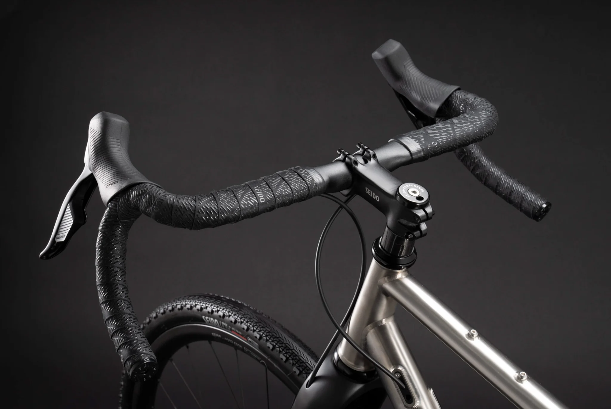 High-angle view of gravel bike handlebars with Seido stem and textured tape.