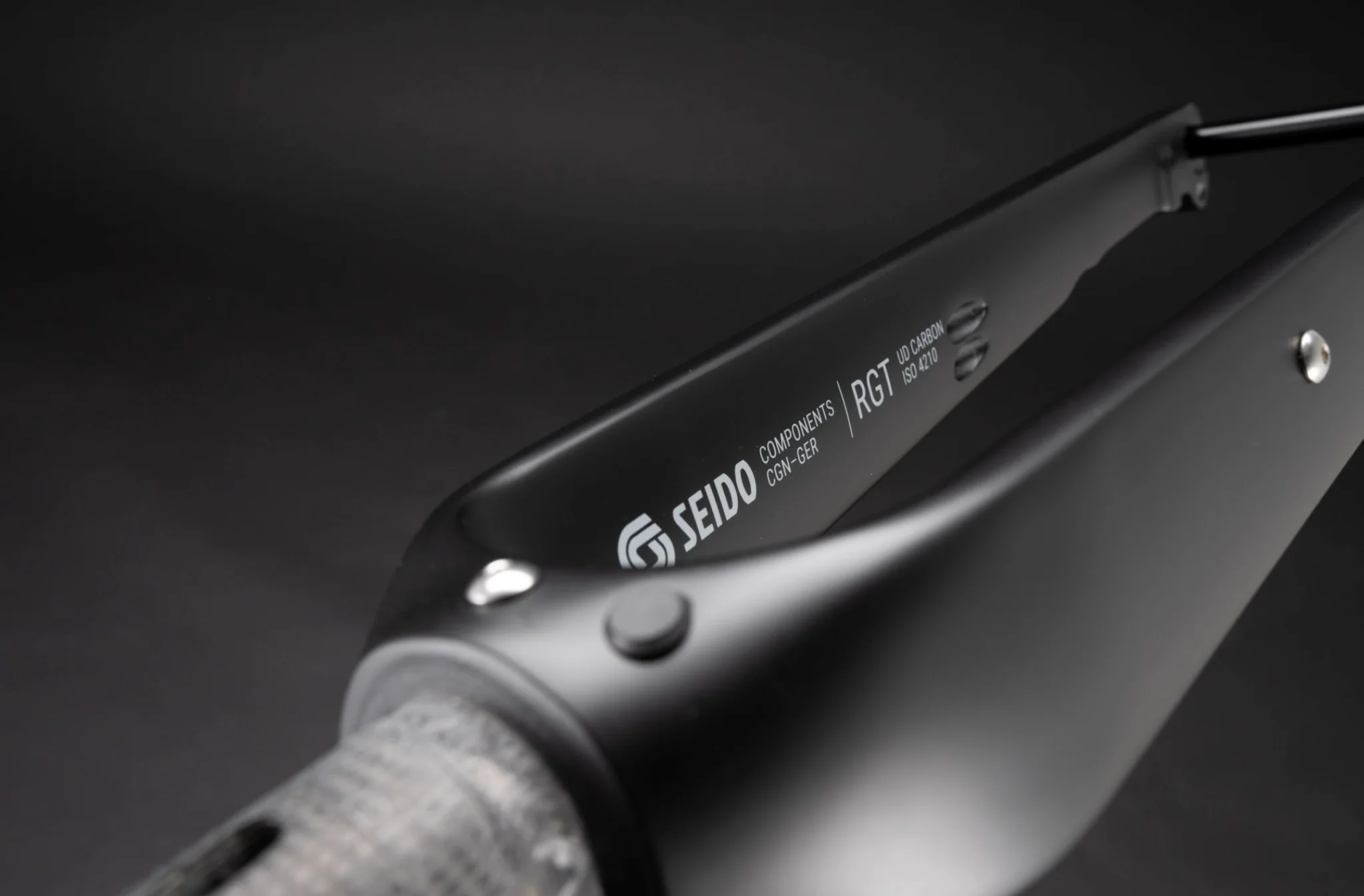 Close-up of a Seido carbon fork crown showing the UD carbon texture and branding.