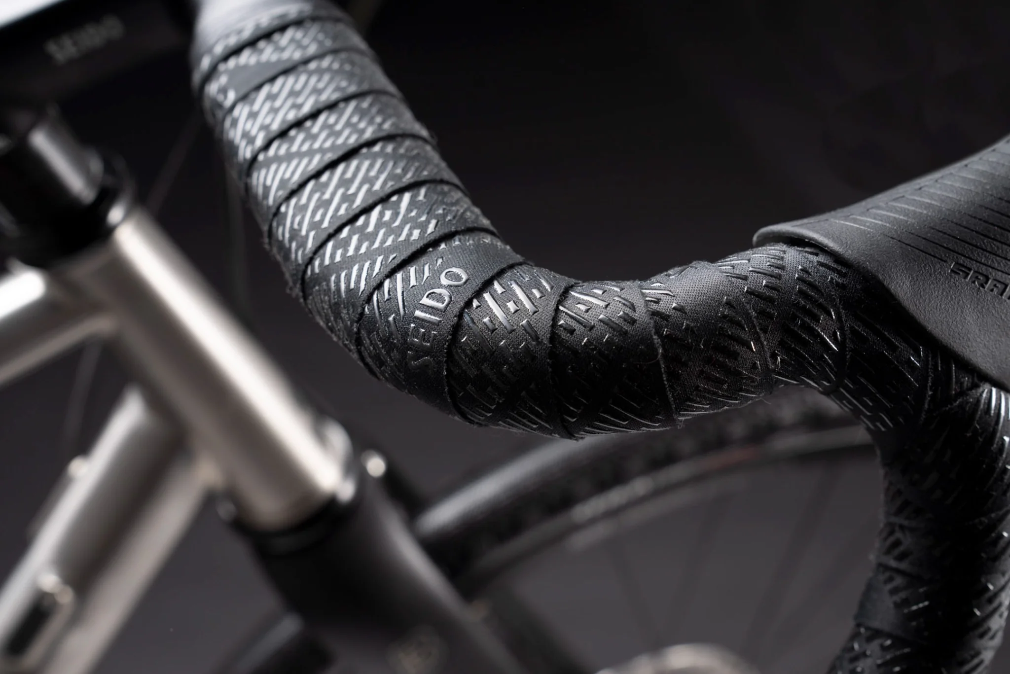 Close-up of Bombtrack drop handlebars with textured Seido tape and levers.