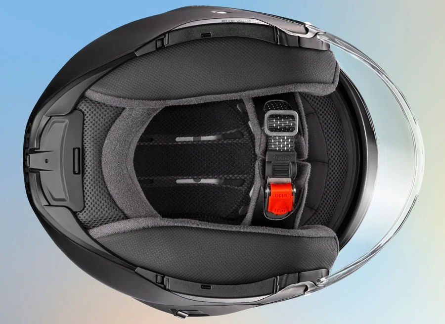 Detailed interior view of a Shoei helmet highlighting plush padding and chin strap.
